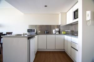 Recoleta Apartment Amazing view -13A- في بوينس آيرس: مطبخ أبيض مع دواليب بيضاء وميكرويف