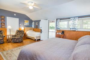 a bedroom with a large bed and a chair at Highland Lake Inn & Resort - Flat Rock in Flat Rock