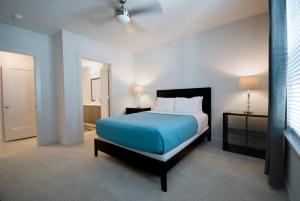 a bedroom with a bed with a blue comforter at BCA Furnished Apartments in Atlanta