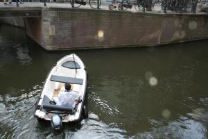 a man in a small boat in the water at Orange City Studio Amsterdam in Amsterdam