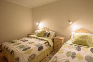 a bedroom with two beds and a dresser at Rossgier Inn in Lifford