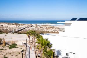 a view of the beach from the balcony of a building at The Beachfront - Praia D'El Rey Golf & Beach Resort in Casal da Lagoa Seca