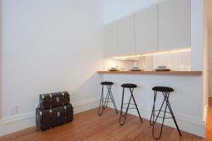 a suitcase sitting on the floor next to two bar stools at Liiiving in Porto | Aliados Luxury Apartments in Porto