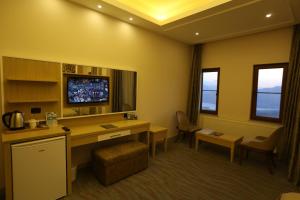 a hotel room with a desk and a tv in it at Ermenek Selcuklu Otel in Ermenek