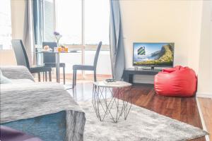 een woonkamer met een rood kussen en een televisie bij Arcadas Cozy Apartments - AU in Funchal