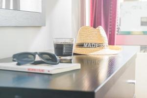 a hat and sunglasses and a glass of water on a table at Arcadas Cozy Apartments - AU in Funchal