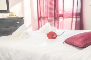 a bed with towels and a red pillow on it at Arcadas Cozy Apartments - AU in Funchal