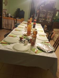 un lungo tavolo con piatti e bottiglie sopra di L'impossibile Guesthouse ad Appiano Gentile