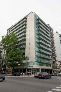 a tall building with cars parked in front of it at Live & Enjoy Buenos Aires in Central Recoleta powered by Argenhost -A12J- in Buenos Aires