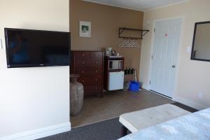 a living room with a television and a kitchen at Clifty Cove Motel in Peggy's Cove