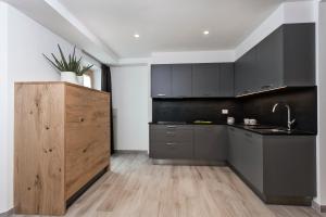 a kitchen with black cabinets and a wooden island at Junior Suite Orso Grigio in Andalo