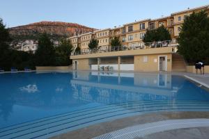a large swimming pool in front of a building at Ermenek Selcuklu Otel in Ermenek