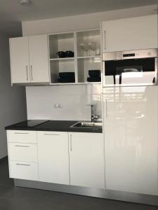 uma cozinha branca com armários brancos e um lavatório em Luxury Apartment Playa del Ingles em Playa del Inglés