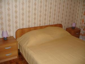 1 dormitorio con 1 cama y 2 mesitas de noche con lámparas moradas en Apartments Deželić, en Cres