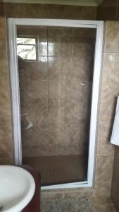 a shower with a glass door in a bathroom at Kleines Nest Bed and Breakfast in Walvis Bay