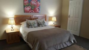 a bedroom with a large bed with two lamps at Kleines Nest Bed and Breakfast in Walvis Bay
