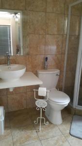bagno con servizi igienici bianchi e lavandino di Kleines Nest Bed and Breakfast a Walvis Bay