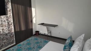 een slaapkamer met een bureau, een bed en een tafel bij Hotel Rosales Plaza in Manizales