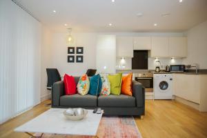 uma sala de estar com um sofá com almofadas coloridas em EXECUTIVE 2 BED APARTMENT em Londres