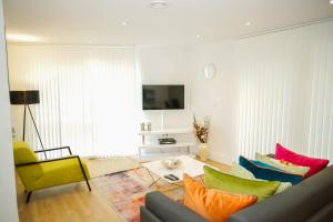 uma sala de estar com um sofá e cadeiras coloridas em EXECUTIVE 2 BED APARTMENT em Londres