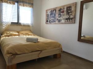 1 dormitorio con cama con espejo y ventana en Luxury Apartments en Midrakh ‘Oz