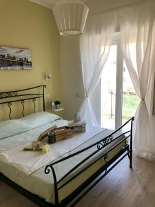 a bedroom with a bed and a large window at AzzurRomare Flat apartment in Lido di Ostia