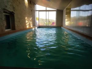 an indoor swimming pool with water in a room at La Roulotte CLERELU - Du domaine des Ramonets in Cahors +8 photos