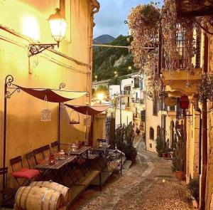 an alley with a table and chairs and an umbrella at Casa delle Galee in Scilla