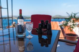 a bottle of wine and a camera on a table with a glass at Holiday home Elin Šibenik in Šibenik +29 photos