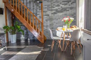 a dining room with a table and chairs and a brick wall at Domek nad Zalewem in Janów Podlaski