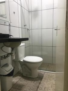 a bathroom with a toilet and a sink at Hotel central campo grande in Campo Grande