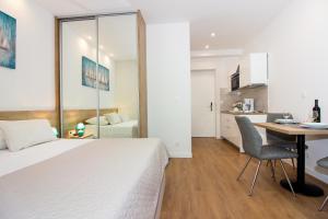 a bedroom with a bed and a desk and a kitchen at Lugo Apartments in Split