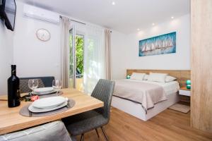 1 dormitorio con 1 cama y 1 mesa con sillas en Lugo Apartments, en Split