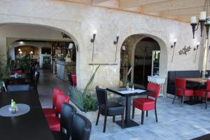 a restaurant with tables and red chairs in a room at Hotel zum Goldenen Wagen in Maulburg