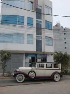 an old car parked in front of a building at Hospedaje Harjeny in Trujillo +33 photos