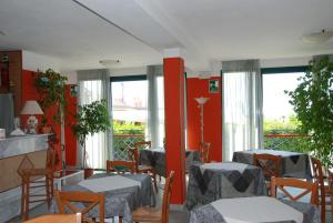 a dining room with tables and chairs and windows at Hotel Turandot in Torre del Lago Puccini +37 photos