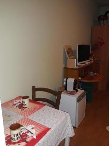 a kitchen with a table and a computer on a desk at Anne's House in San Giuliano Terme