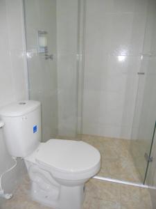 a white bathroom with a toilet and a shower at Hotel Manzanares Baranoa in Baranoa