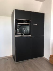 a black cabinet with a microwave in a room at Ferienwohnung Kohls in Steinheim