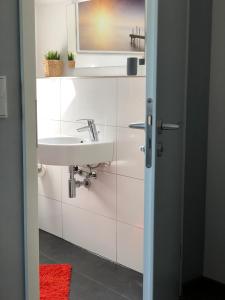 a white bathroom with a sink and a mirror at Ferienwohnung Kohls in Steinheim