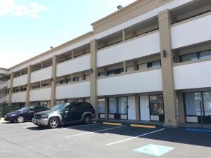 a large building with cars parked in a parking lot at Super 8 by Wyndham WestEnd Alexandria,VA Washington DC Area in Alexandria