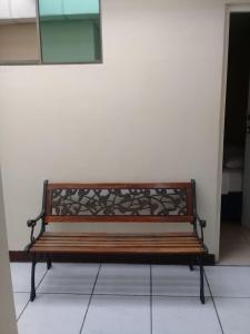 a wooden bench sitting next to a wall at Hotel Madriz in Managua