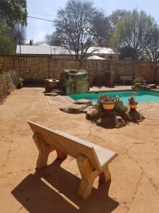 a bench sitting in front of a swimming pool at Upper Houghton Guesthouse in Johannesburg