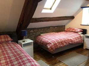 a attic bedroom with two beds and a window at Llwyn Llwyd Cottage in Brecon