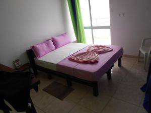 een slaapkamer met een bed met paarse lakens en een raam bij Guest House Frontera in Pinto