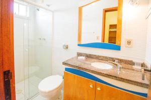 a bathroom with a toilet and a sink and a mirror at Pousada Lugar ao Sol in Bombinhas