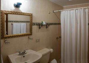 y baño con lavabo y espejo. en Hostal Villa Toscana, en Guatemala