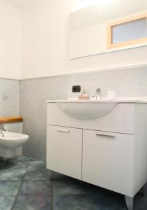 een witte badkamer met een wastafel en een toilet bij premesan in Bormio