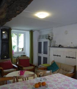 een woonkamer met een tafel en stoelen bij les Miquelots in Pont-d'Ouilly