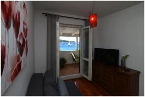 a living room with a couch and a television at Apartment Slavko in Primošten